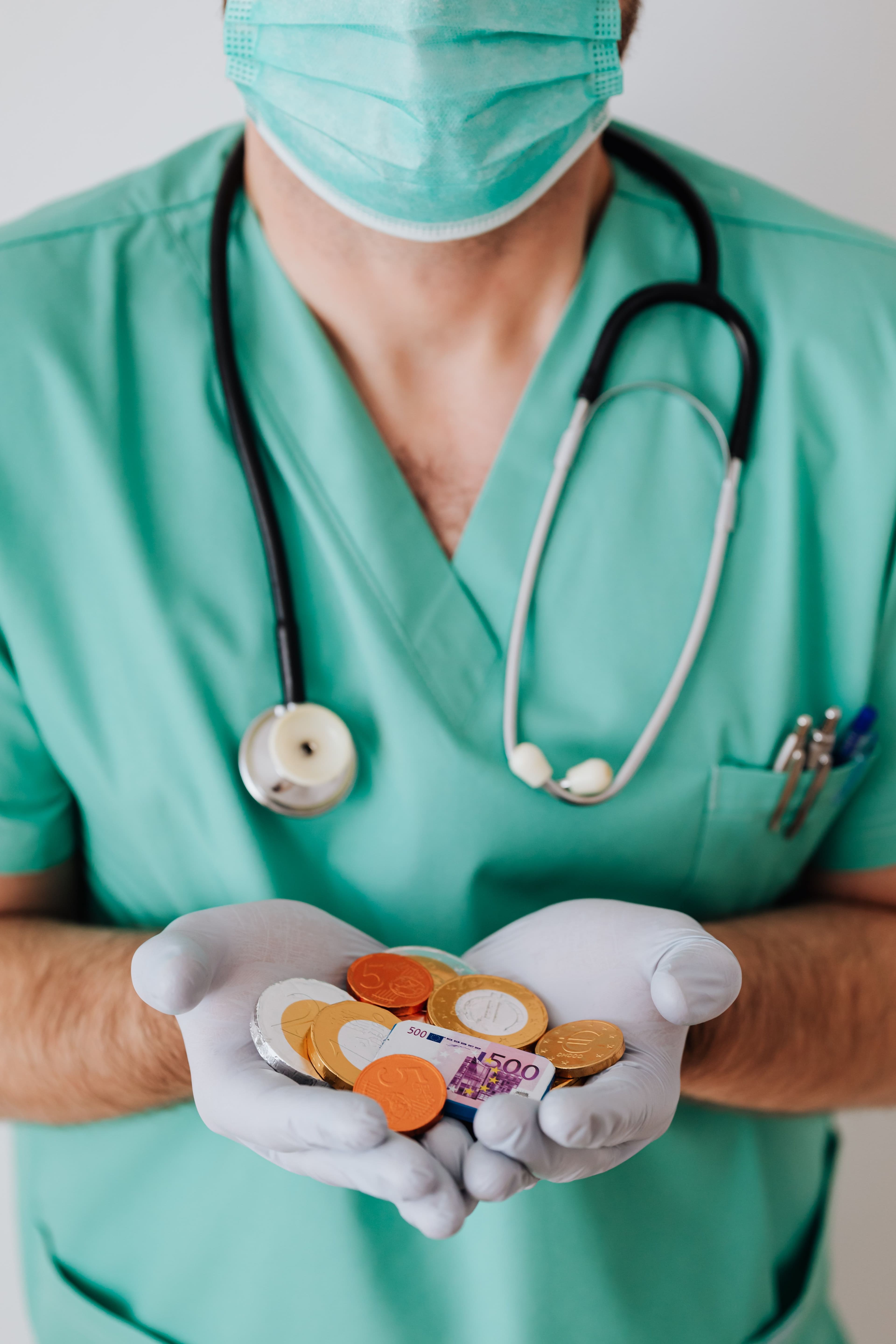 A healthcare professional holding money to represent healthcare costs