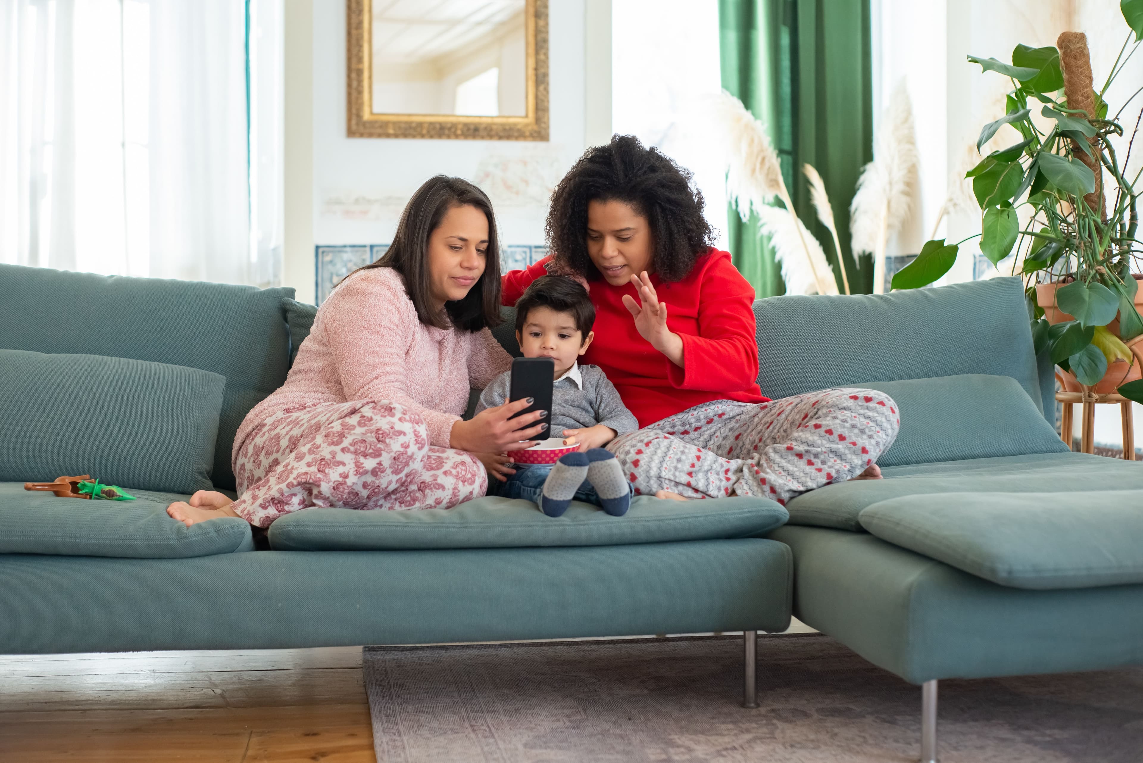 Two mothers sitting at home with their child
