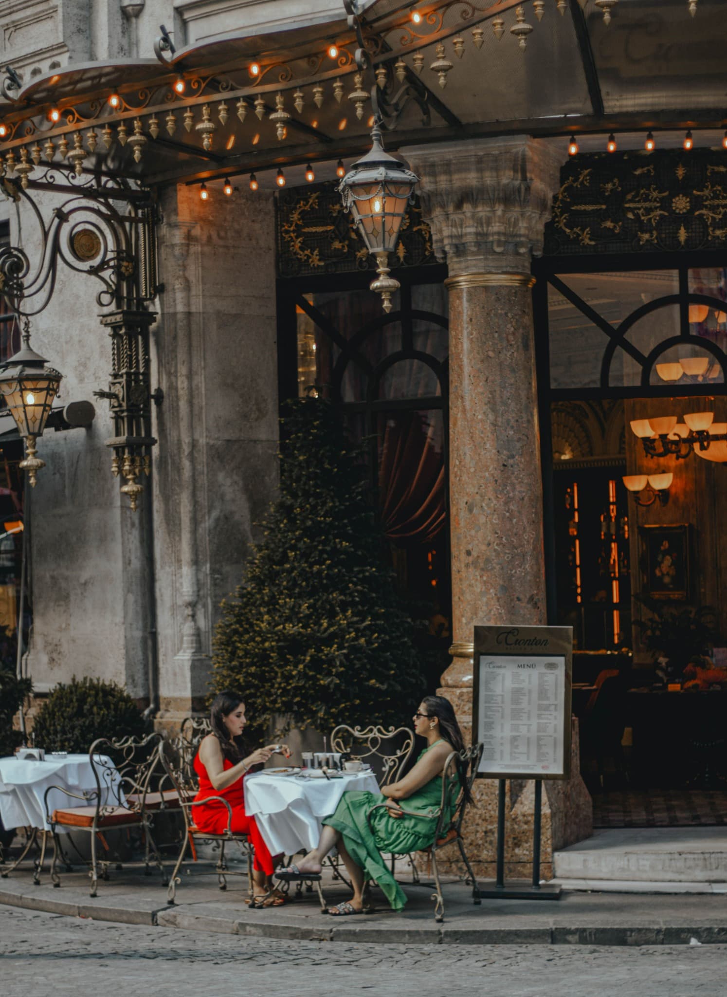 Two people enjoying an elegant outdoor café setting abroad
