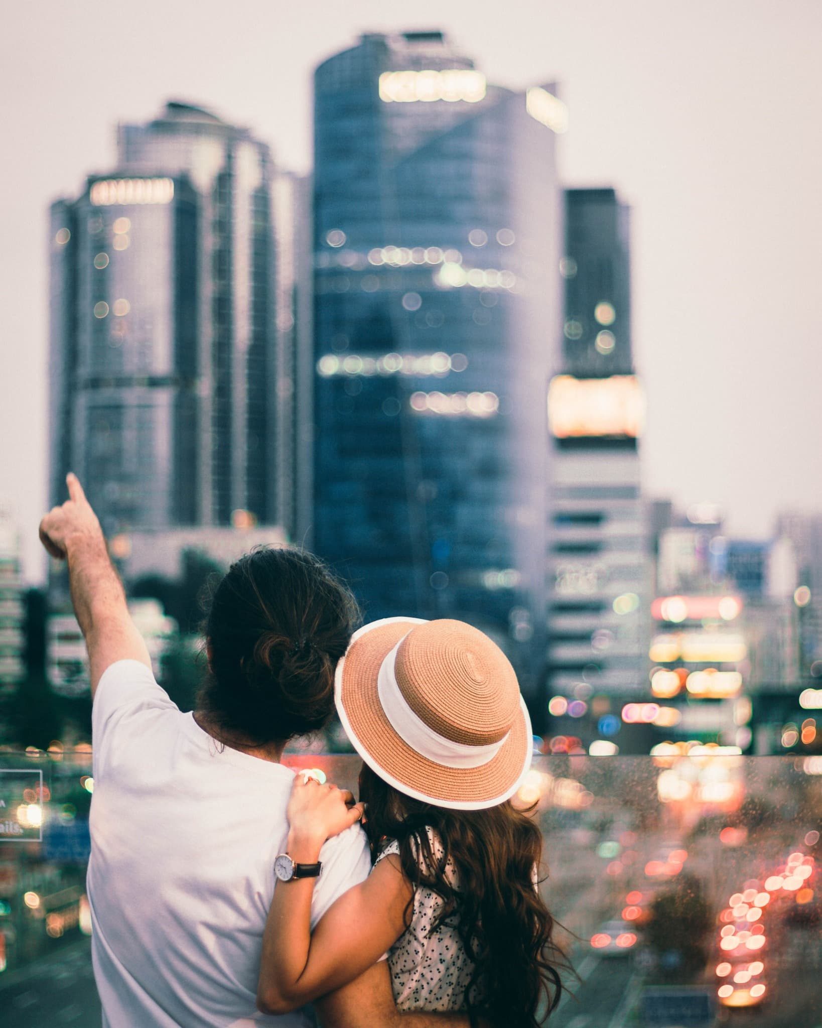 A couple looking across a vibrant modern city