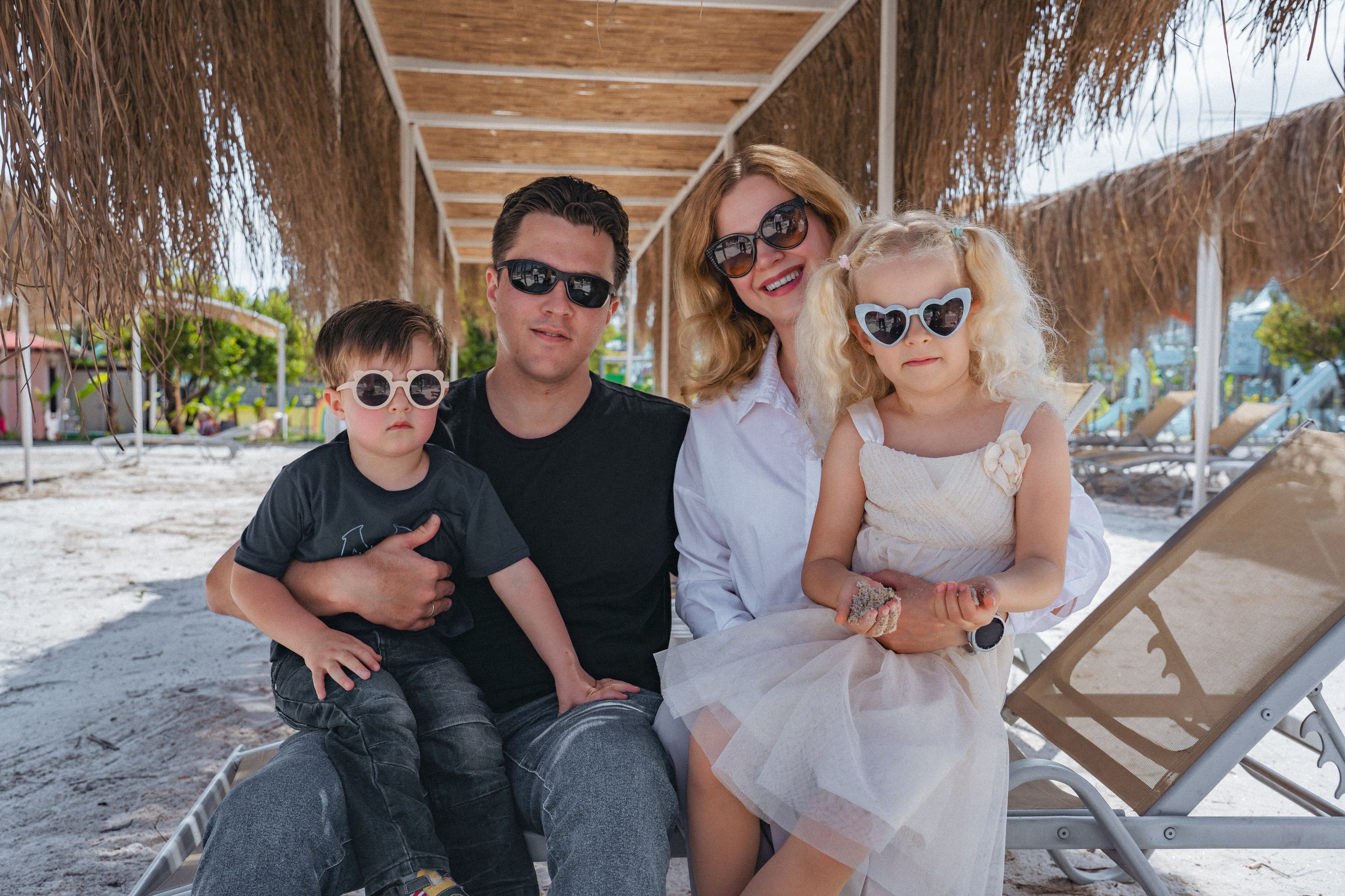 A family with two children sitting together by the beach
