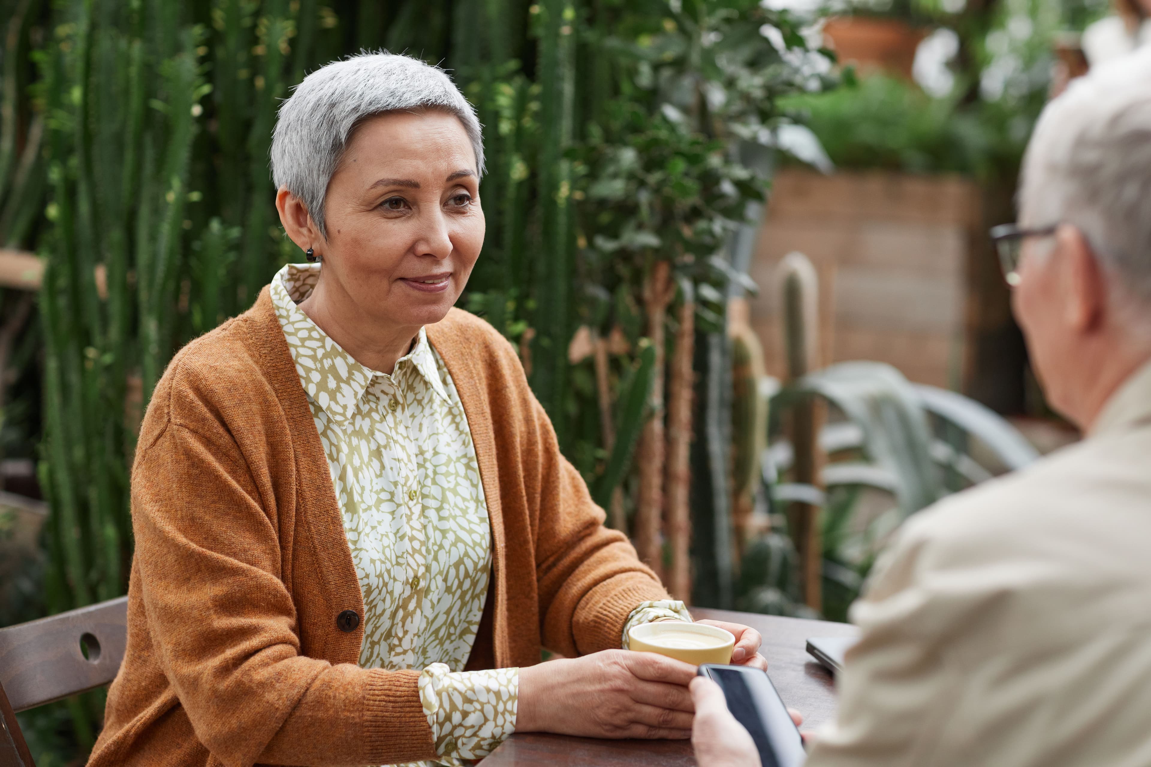 A retiree having a thoughtful conversation over coffee